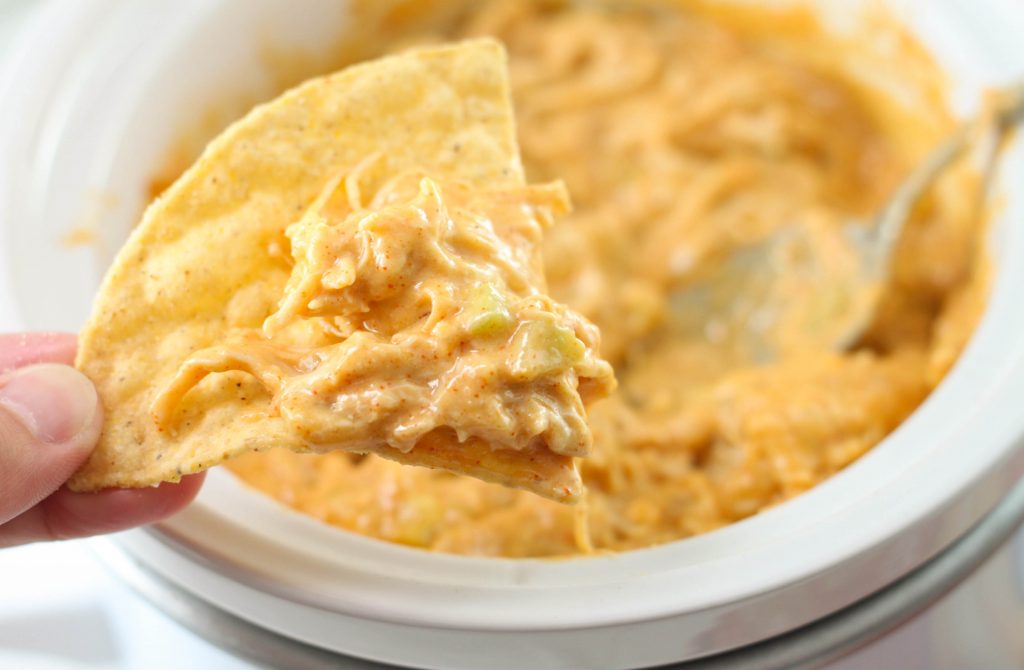This Crock Pot Chicken Enchilada Dip is the perfect, easy dip recipe for a party appetizer or to snack on during the game