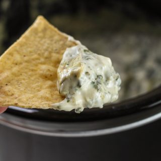 Are you looking for an easy Crock Pot Spinach and Artichoke Dip? Look no further! This recipe is cheesy, delicious and perfect for tailgating or parties.